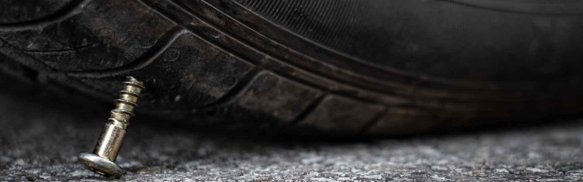 Close up button head needle metal screw nail stuck to puncture into wheel tire on the road Stockphoto_Flat Tyre with nail_contact met 11D